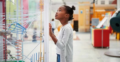 Young black girl looking at a science exhibit