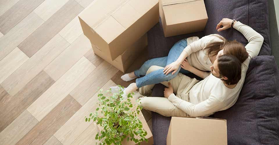 Young couple owners moved into new home resting on couch