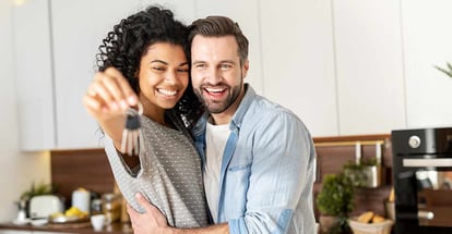 Young couple smiling and showing their new house keys