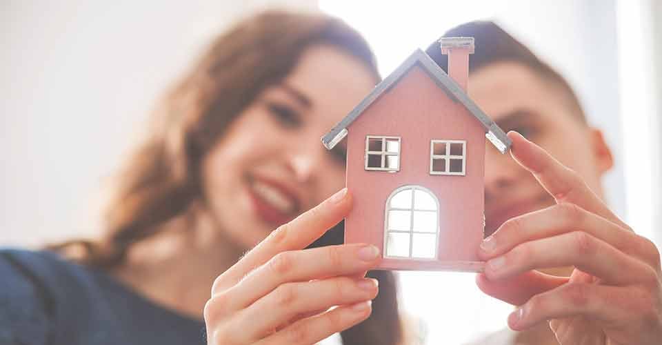 Young couple with small wooden house
