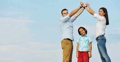 Young family on green summer grass meadow building dream new home