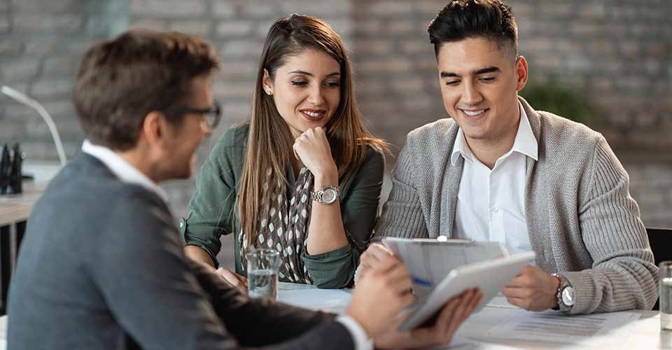 Young happy couple having consultations with bank manager on a meeting in the office