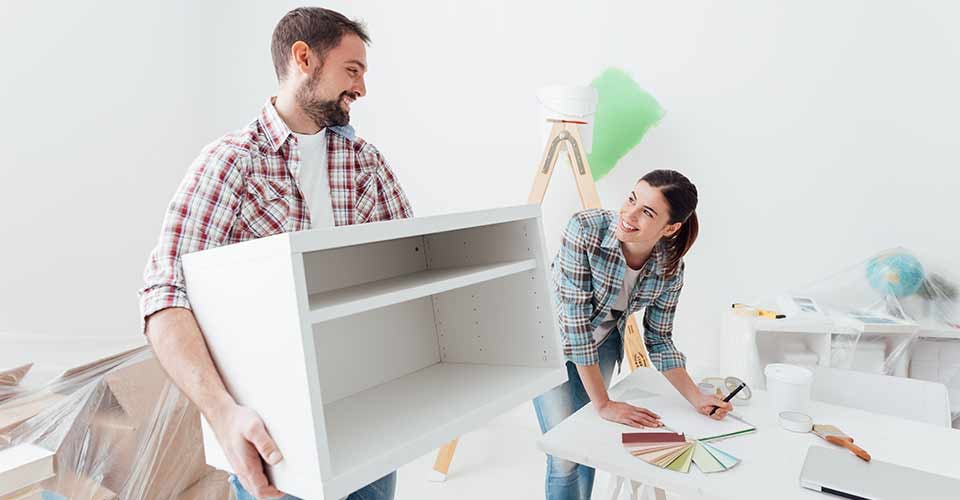 Young happy couple renovating their new house and moving furnishings together