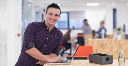 Young man in casual clothes working on laptop
