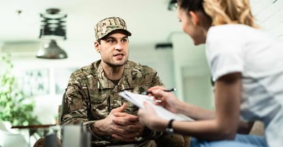 Young military man talking to someone at home