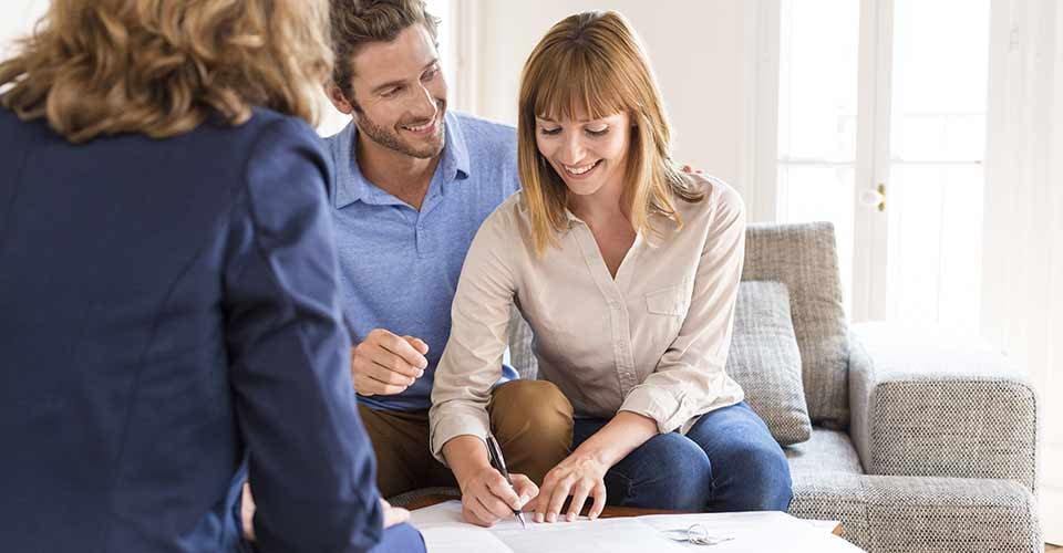Young owners couple signing a contract for house