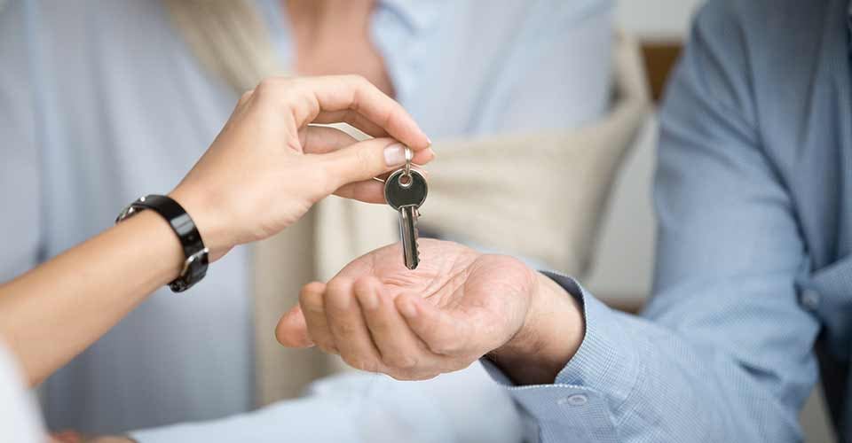 Homeowners getting key to new house from realtor