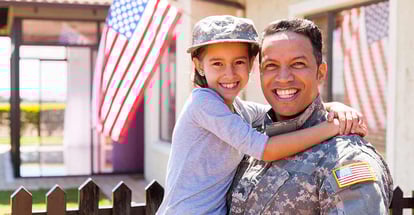 Portrait of us army soldier and little daughter outside their home