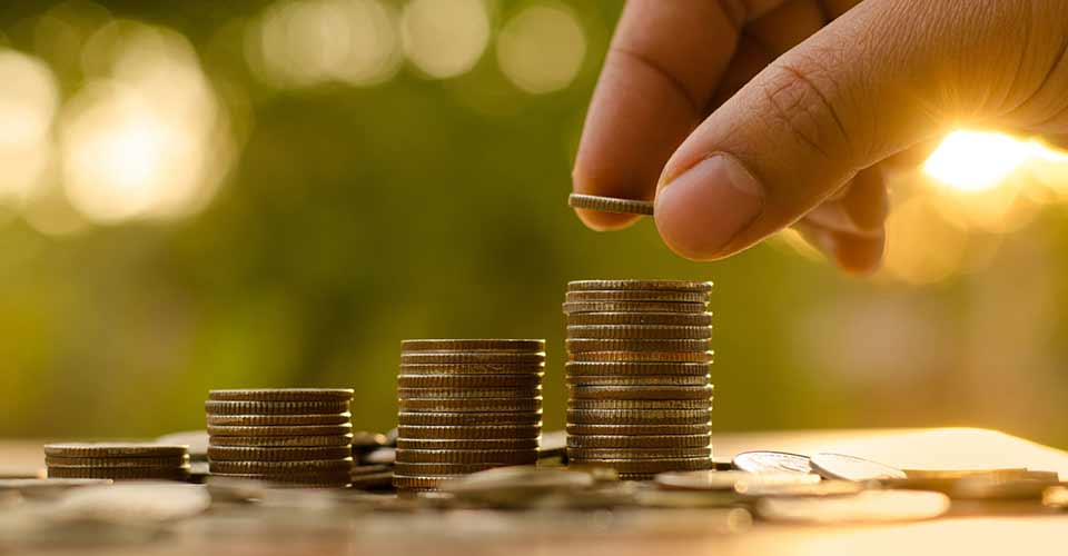 Closeup of male hand putting money coin stack