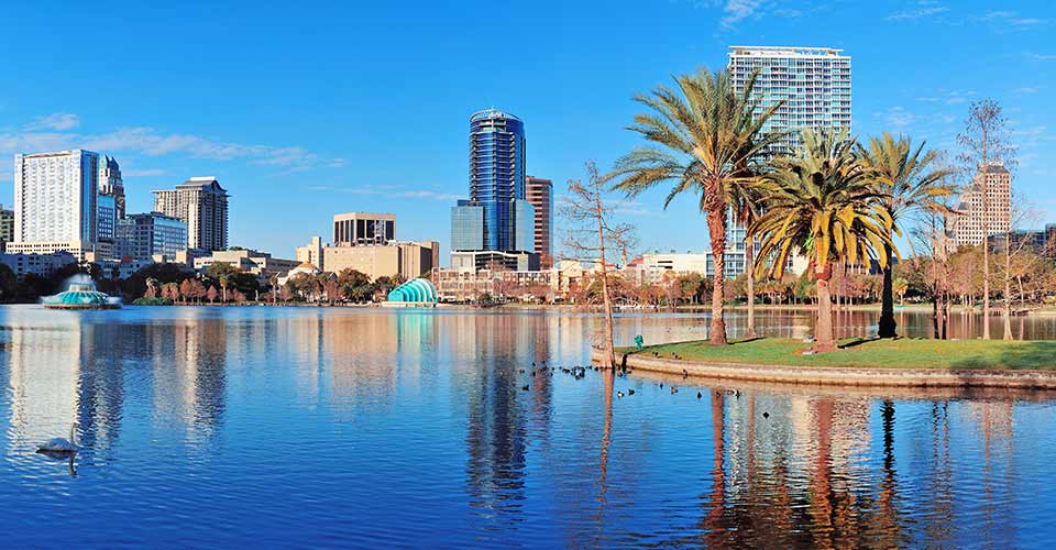 Lake Eola in the morning with urban skyscrapers and clear blue sky in Orlando Florida