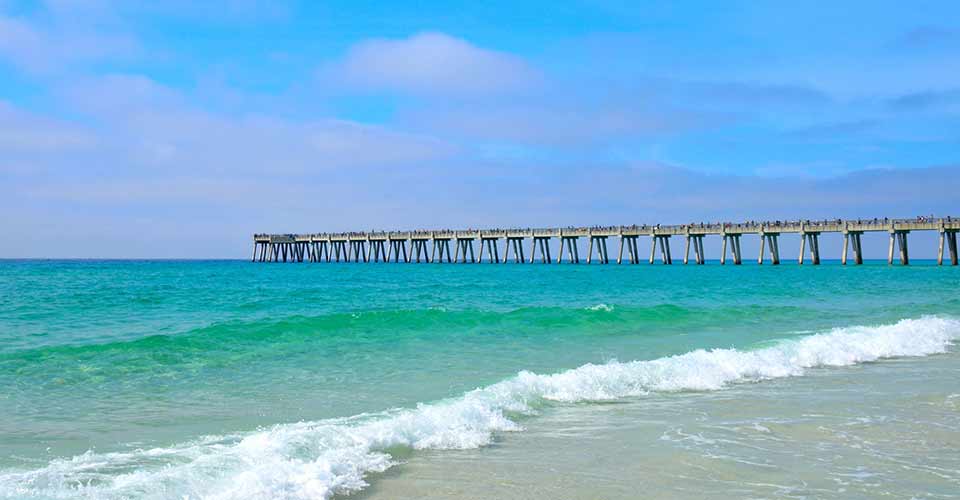 Pier extending out over the blue green ocean at Panama City in Florida