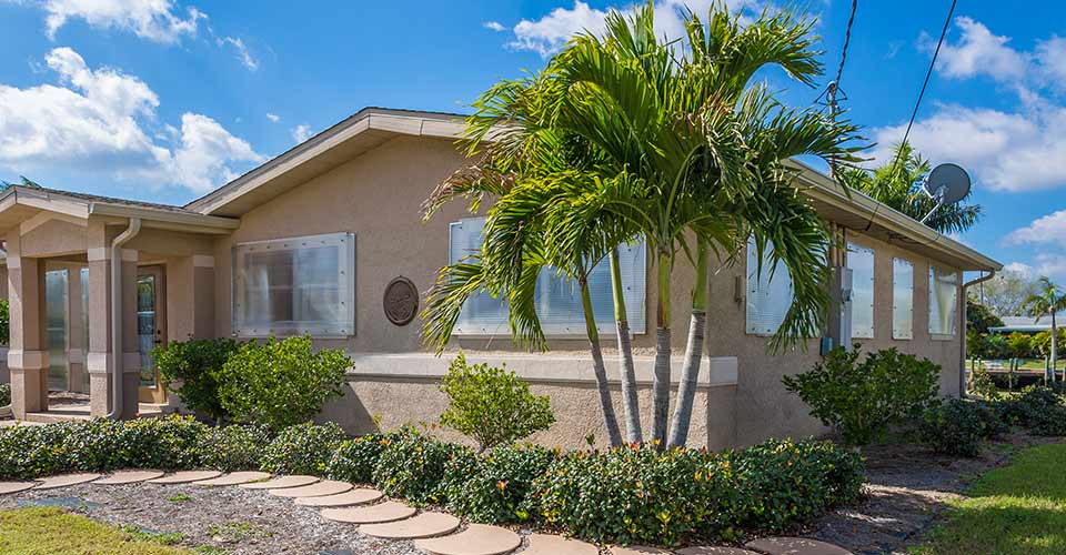 Typical Concrete Block and Stucco Home with palm trees in Florida
