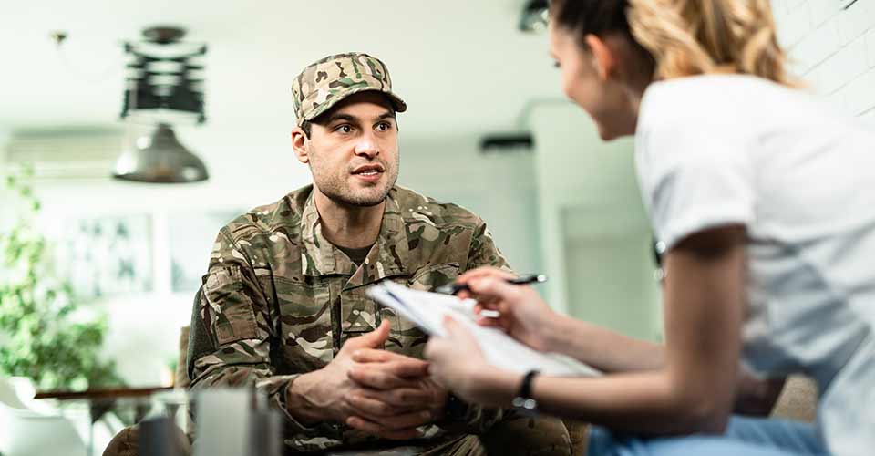 Young military man talking to someone at home