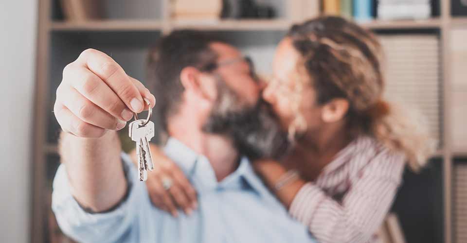Keys held by excited young spouses homeowners